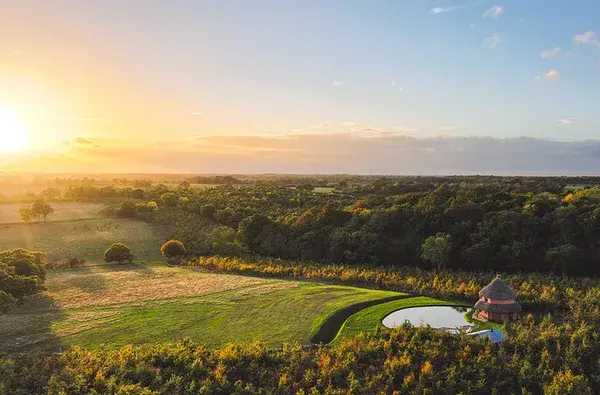 Aerial view of the estate at sunset with a hidden roundhouse beside a pool